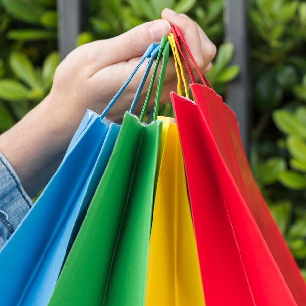 La mano de la señora con bolsas brillantes.