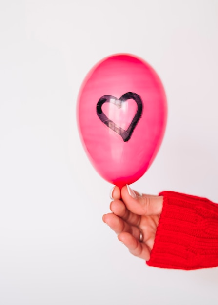 Foto gratuita mano de señora con globo con corazón pintado.