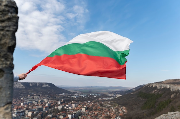 Mano sosteniendo la bandera búlgara al aire libre