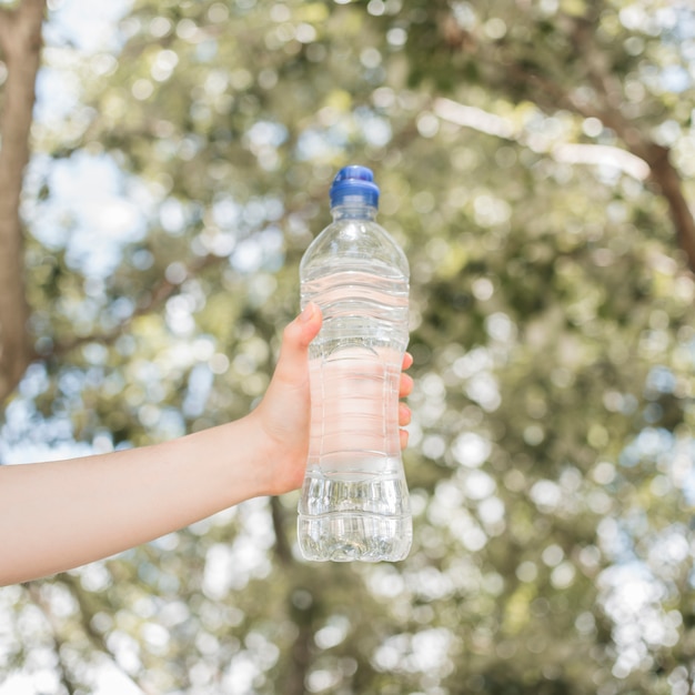 Mano sosteniendo botella de agua