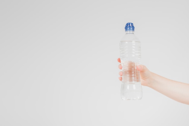 Mano sosteniendo botella de agua