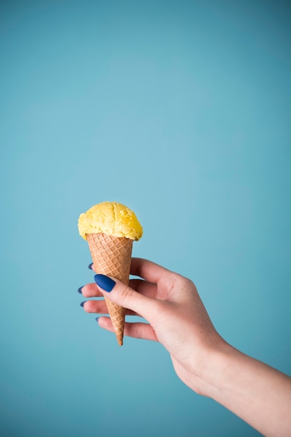 Mano sosteniendo delicioso helado