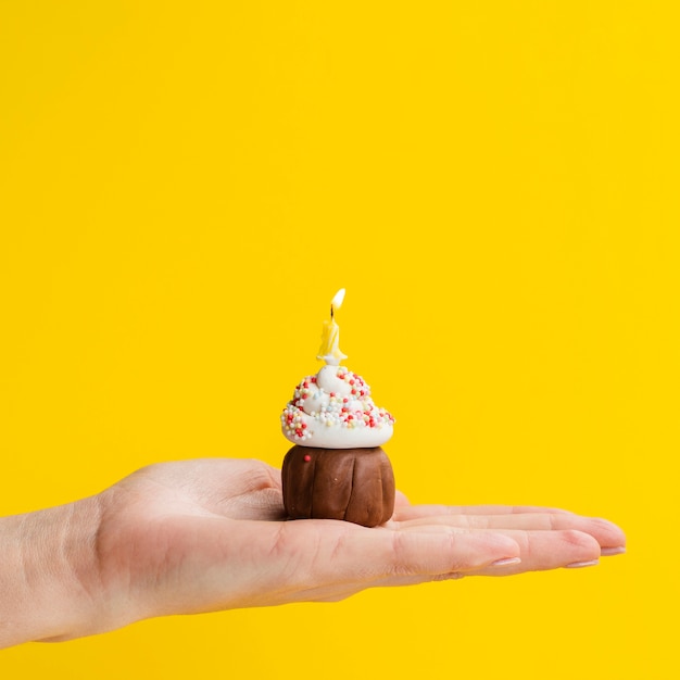 Mano sosteniendo delicioso postre pequeño