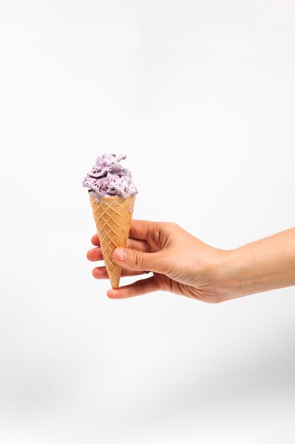 Mano sosteniendo helado en taza de oblea