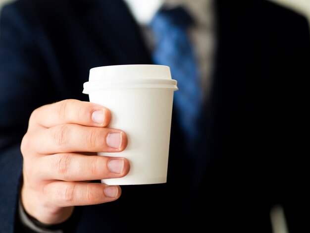 Mano sosteniendo maqueta de taza de café