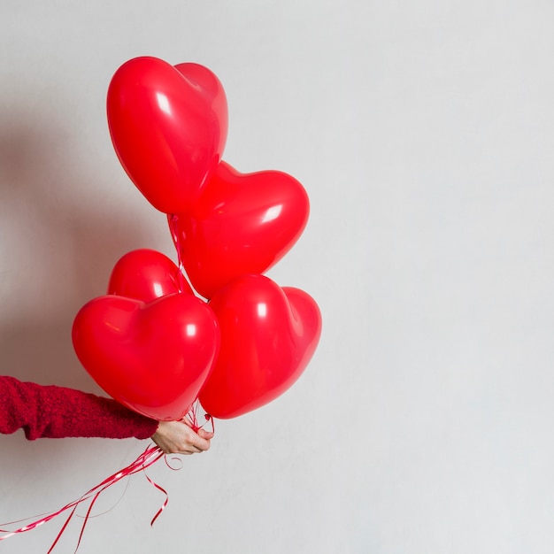 Mano sosteniendo un montón de globos