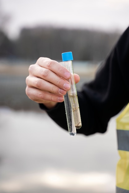 Mano sosteniendo muestras de agua del río