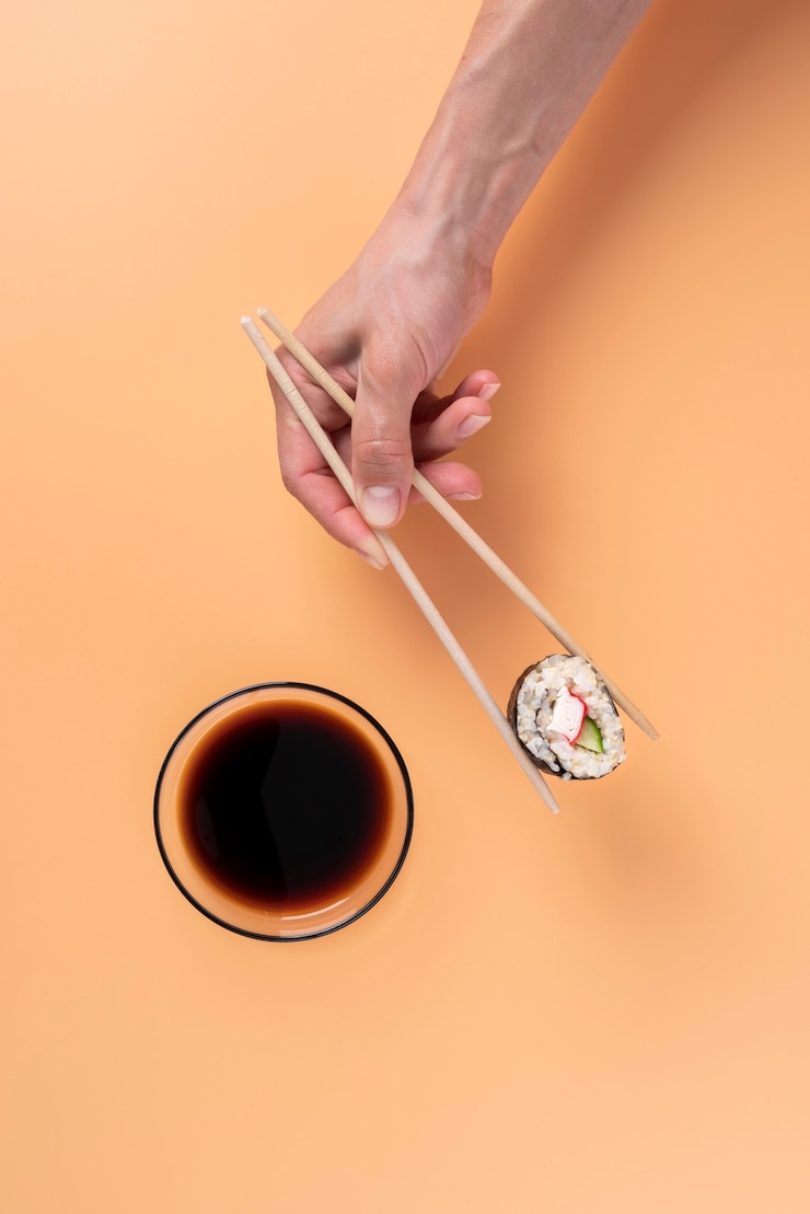 Foto gratuito mano sosteniendo palillos comida asiática