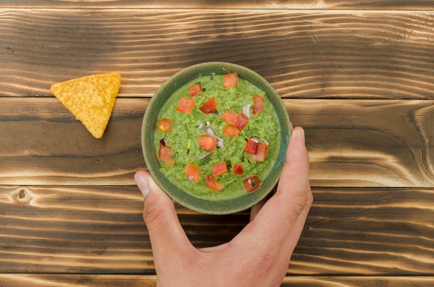 Foto gratuita mano sosteniendo la taza de adornar cerca de nacho