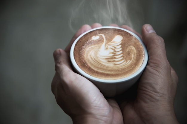 Mano sosteniendo una taza de café caliente