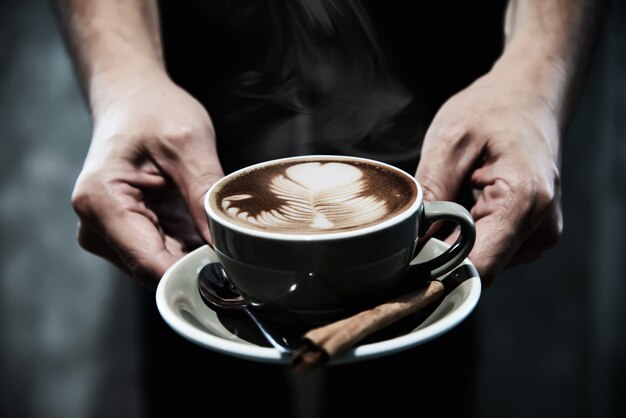 Mano sosteniendo una taza de café caliente