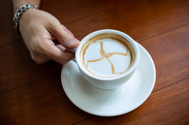 Mano sosteniendo la taza de café caliente