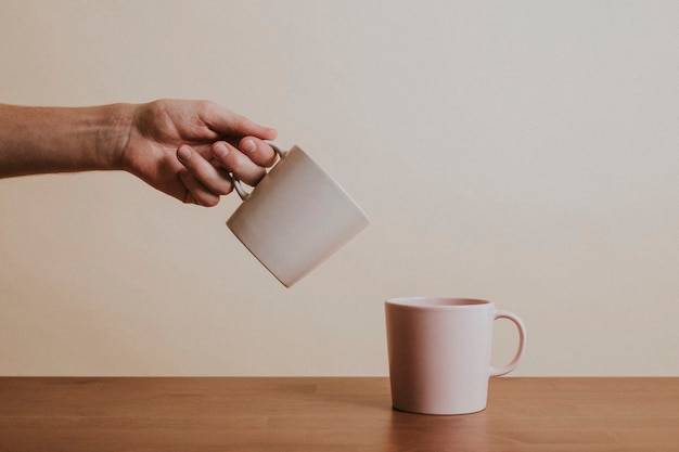 Foto gratuita mano sosteniendo una taza de café de cerámica