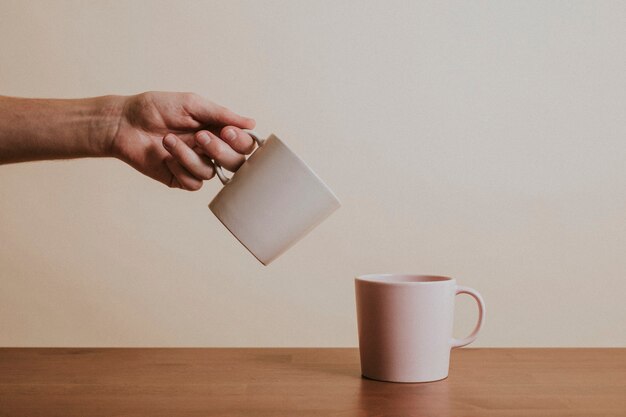 Mano sosteniendo una taza de café de cerámica