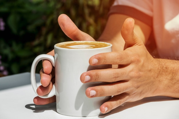 Foto gratuita mano sosteniendo taza de café