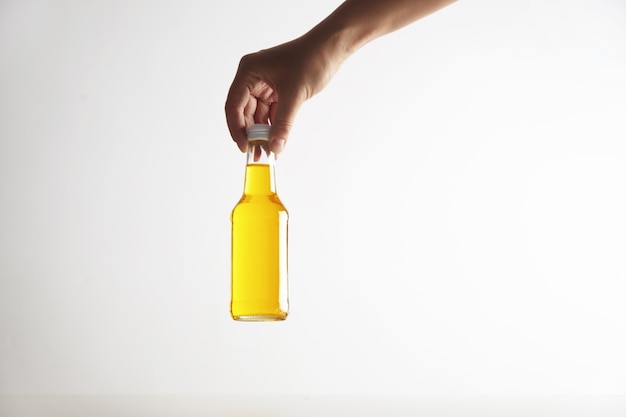 Foto gratuita la mano sostiene la botella de vidrio rústico cerrado con una sabrosa bebida fría en el interior