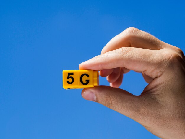 Mano sujetando 5g snap cubos contra el cielo