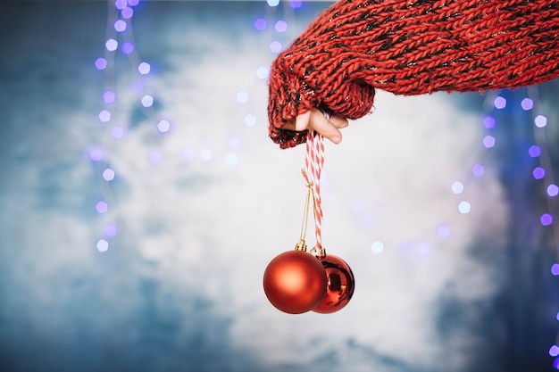 Mano sujetando bola de navidad elegante roja