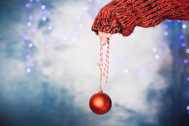 Foto gratuita mano sujetando bola de navidad roja