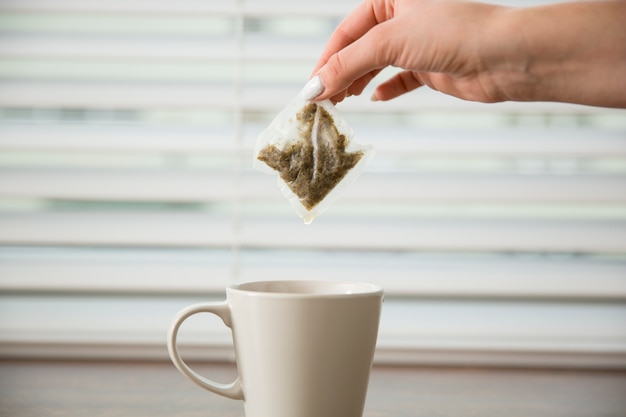 Foto gratuita mano sujetando bolsa de té