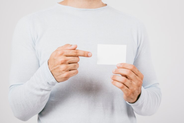 Foto gratuito mano sujetando una tarjeta de visita y dedo señalando