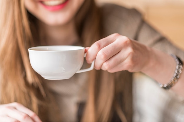 Mano sujetando una taza blanca