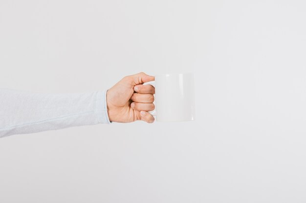 Mano sujetando una taza de café de perfil