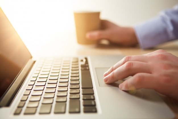 mano en el teclado y café