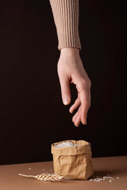 Mano tomando arroz del concepto de zakat de bolsa