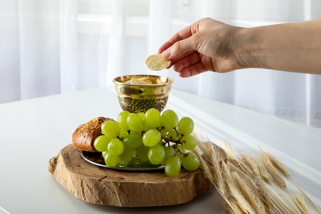 Mano tomando pan sacramental del cáliz