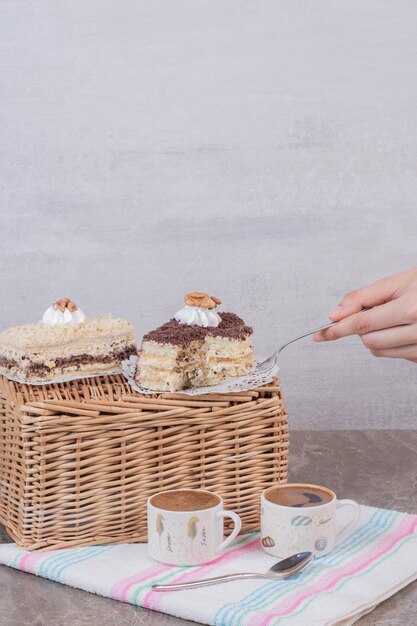 Mano tomando un trozo de tarta en la mesa blanca.