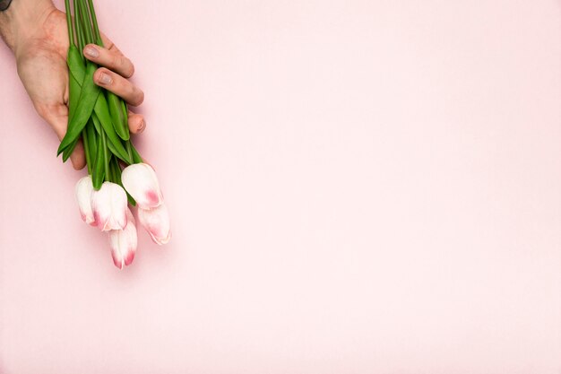 Mano con tulipanes y espacio de copia