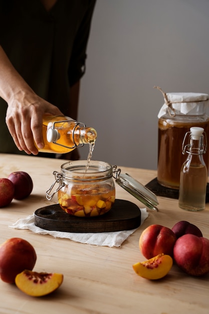 Foto gratuita mano vertiendo kombucha en tarro