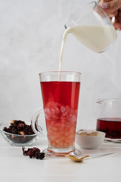 Mano vertiendo leche en té de burbujas