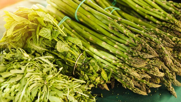 Manojo de espárragos con rúcula y menta en el mercado