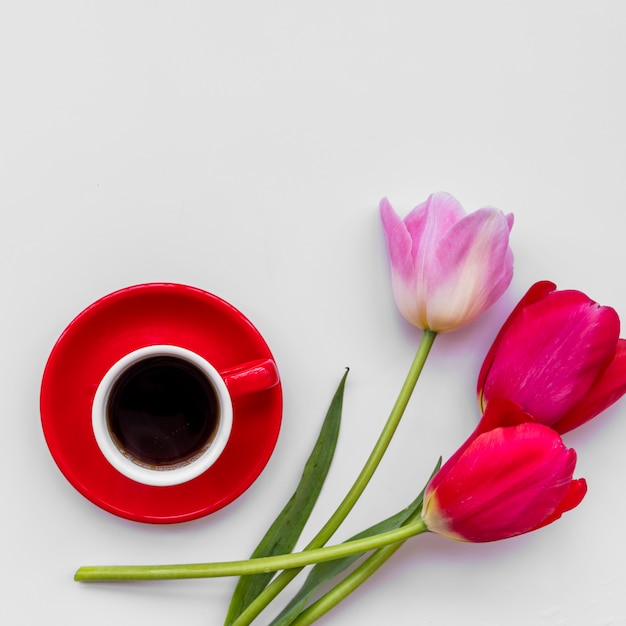 Foto gratuita manojo de flores frescas cerca de la taza de café