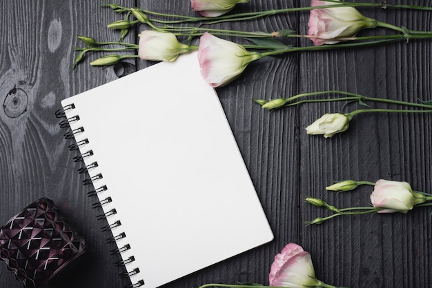 Foto gratuita manojo de flores púrpura eustoma en cuaderno espiral en blanco