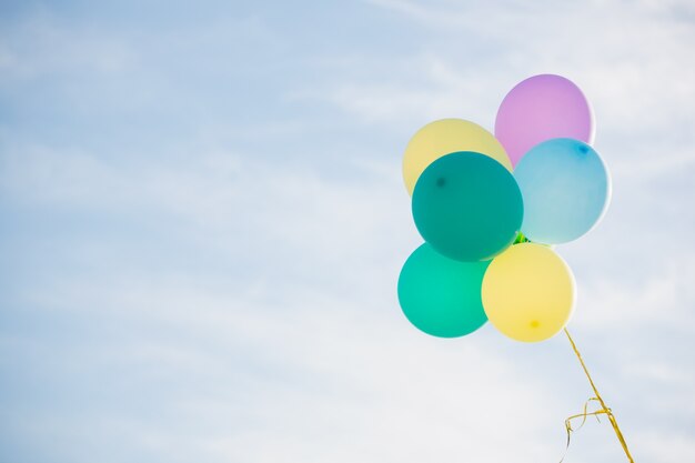 El manojo de globos de colores pastel que flota en el aire