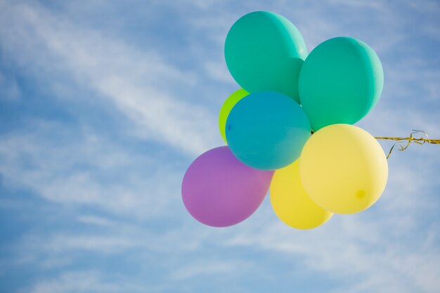 El manojo de globos de colores pastel que flota en el aire