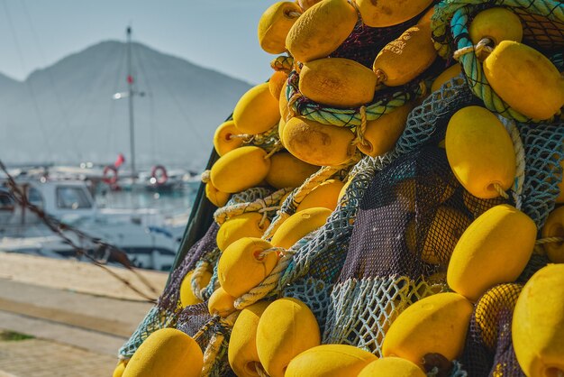Manojo de redes de pesca multicolores enredadas con flotadores amarillos en el fondo del enfoque selectivo del primer plano del puerto deportivo Fondo para el concepto de pesca tradicional en las ciudades costeras