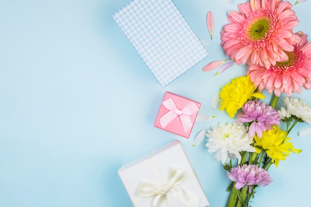 Manojos de flores frescas cerca de cajas y decoraciones actuales.