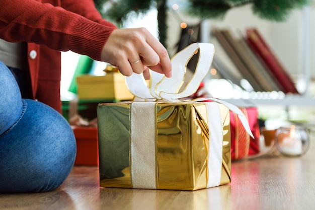 Manos abriendo un regalo amarillo