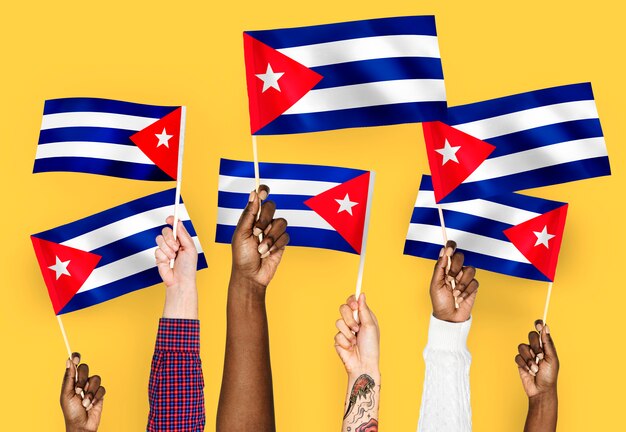 Manos agitando banderas de cuba