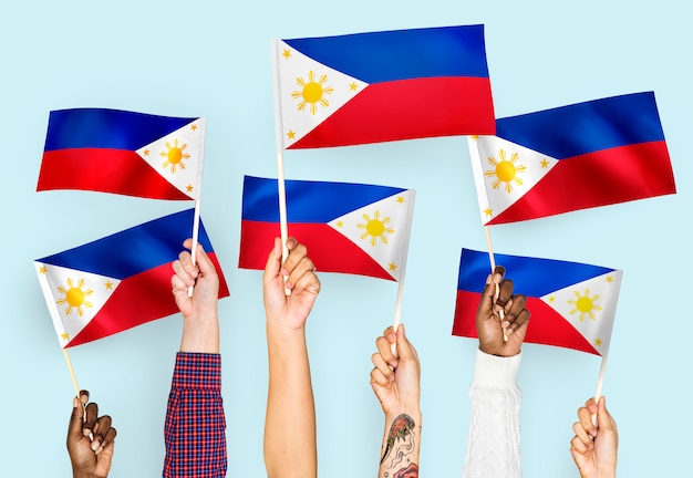 Manos agitando banderas de las filipinas