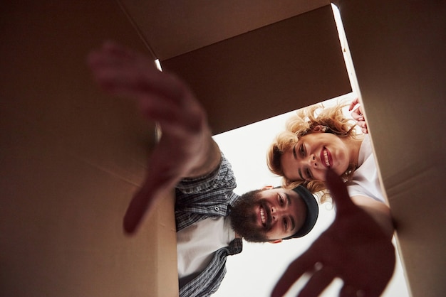 Con manos alargadas. Pareja feliz juntos en su nueva casa. Concepción de mudanza