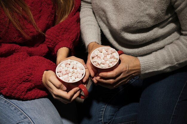 Manos de alto ángulo con bebidas navideñas