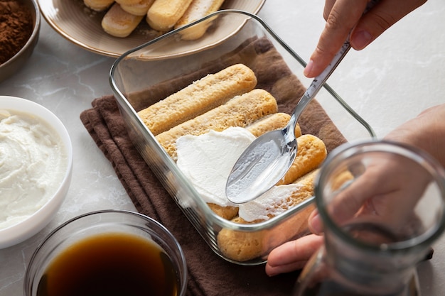 Foto gratuita manos de alto ángulo cocinando tiramisú