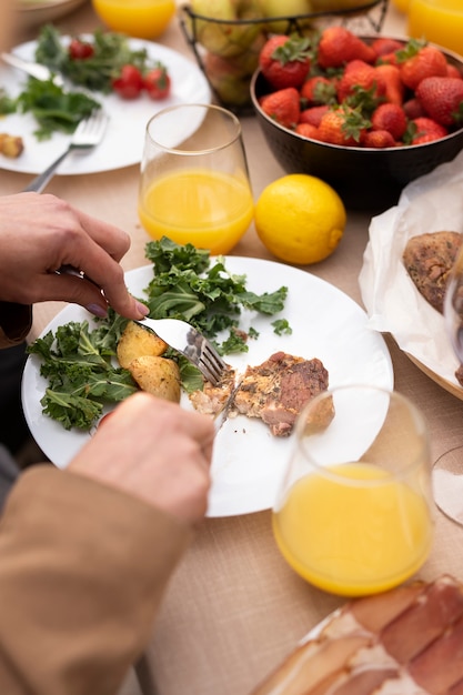 Manos de alto ángulo cortando comida