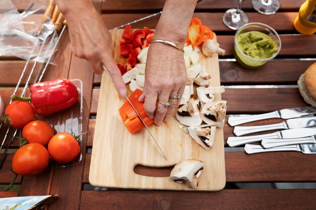 Manos de alto ángulo cortando verduras