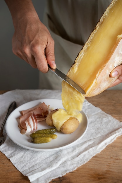 Foto gratuita manos de alto ángulo poniendo queso derretido en la comida